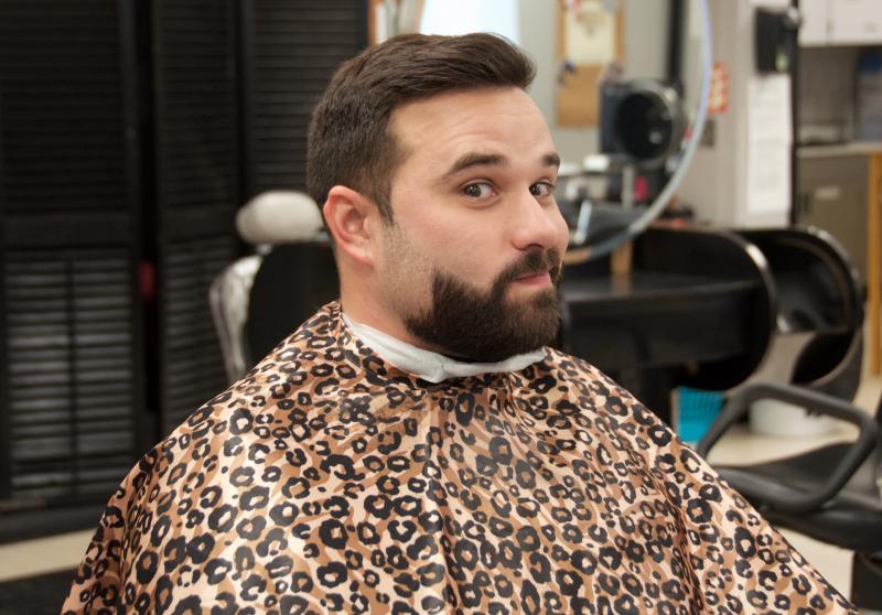 Rochester Police Officer Nathan Valente waits while his hair stylists gets a stronger clipper to shave his thick beard. BY GEORGIA SPARLING